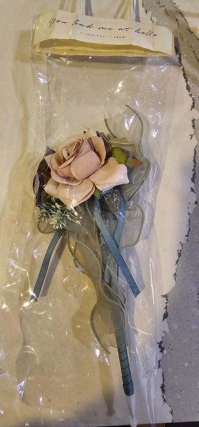 N/A An elegant pen wrapped with ribbon with floral accents on top